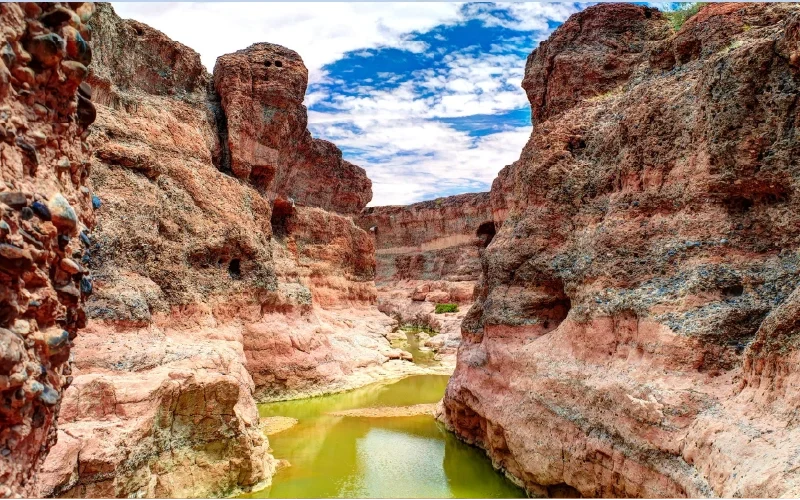 A pool surrounded by rocky canyon walls
