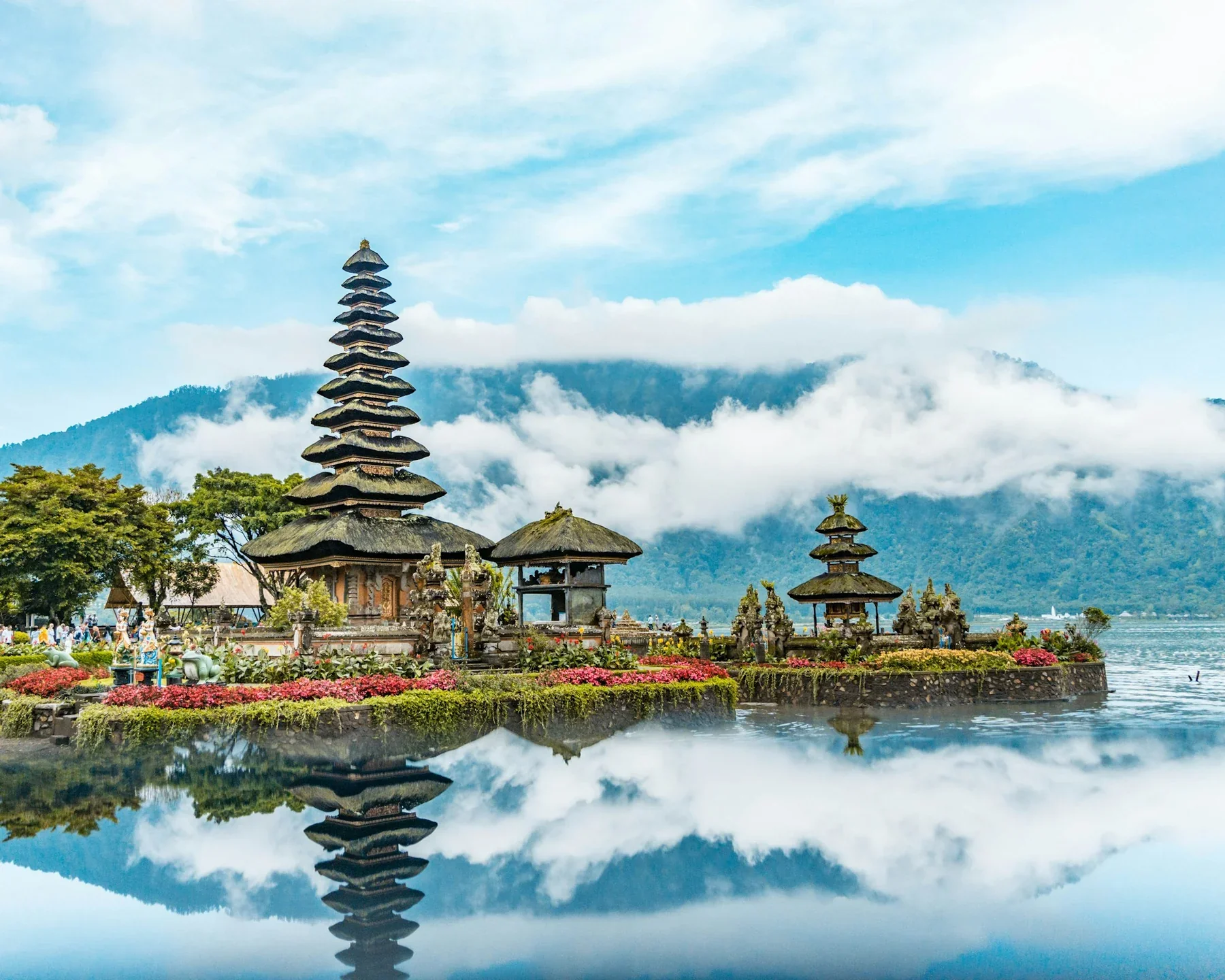 Ulun Danu Beratan Temple reflected in a lake beneath misty mountains in Bali