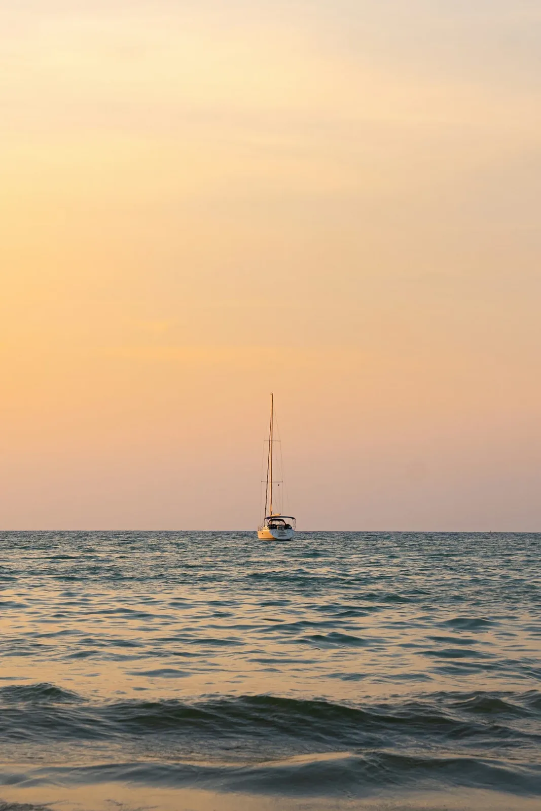 A sailboat on the ocean at sunset